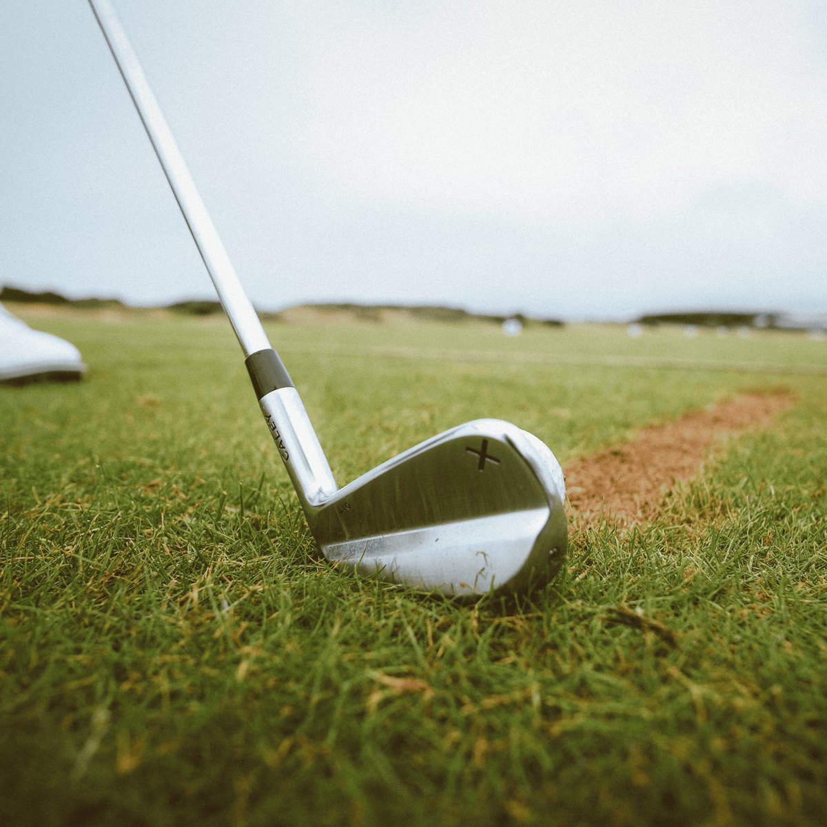 Caley 01 iron addressing the ball on a links fairway